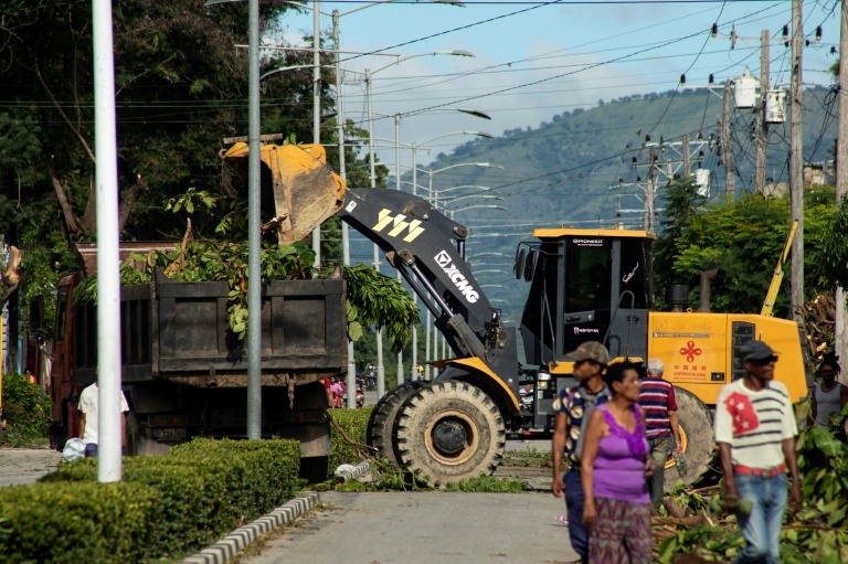 Des équipes dégagent les branches d’arbres élaguées avant l’arrivée de Melissa à Santiago de Cuba, le 25 octobre 2025.