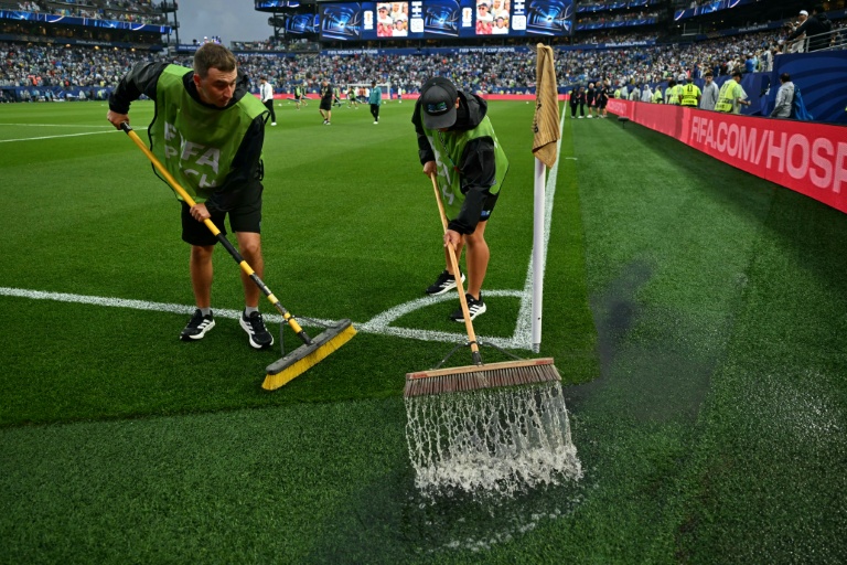 Des membres de l'entretien des terrains tentent d'évacuer l'eau de la pelouse du stade de Philadelphie durant une longue interruption du match France-Irak en phase de poules du Mondial, le 22 juin 2026