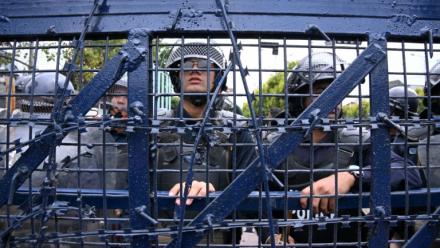 Des policiers montent la garde lors d'une manifestation de partisans de l'ancien Premier ministre népalais KP Sharma Oli protestant contre son arrestation, le 29 mars 2026 à Katmandou, au Népal