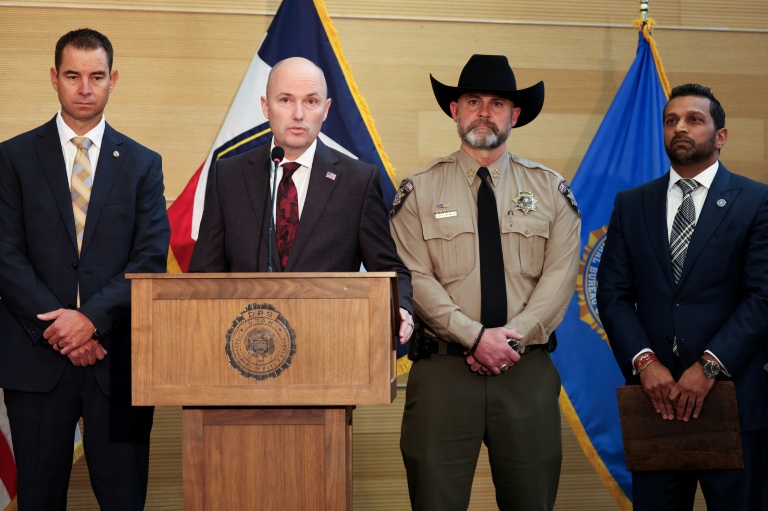 Le gouverneur de l'Utah Spencer Cox s'exprime au micro lors d'une conférence de presse à Orem (Utah), avec notamment le directeur du FBI Kash Patel (tout à droite), le 12 septembre 2025