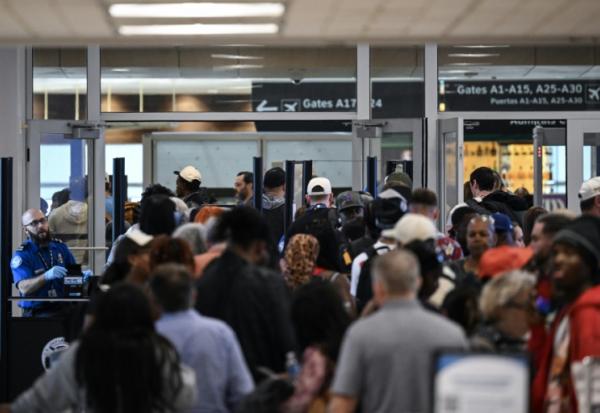 Des voyageurs patientent dans de longues files d'attente aux contrôles de sécurité de l'aéroport intercontinental George Bush de Houston, au Texas, le 23 mars 2026