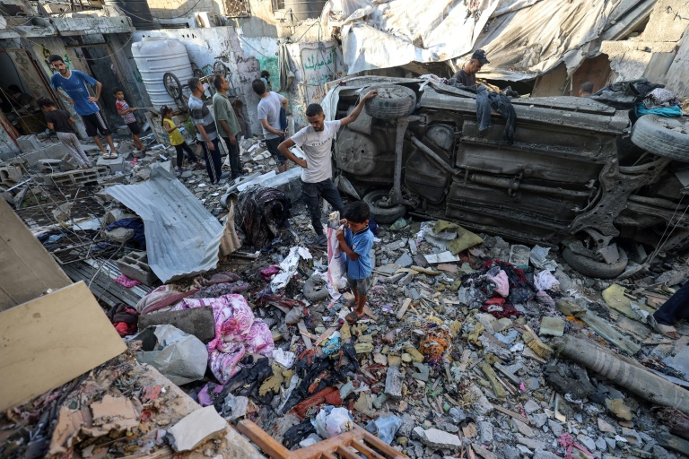 Des Palestiniens fouillent les décombres après une frappe aérienne sur le camp de réfugiés de Nousseirat, dans le centre de la bande de Gaza, le 27 septembre 2025