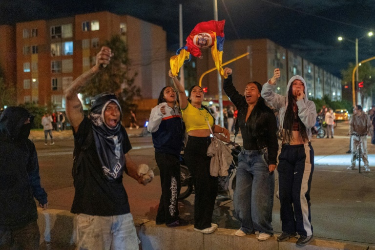 Des manifestants brandissent des drapeaux et tiennent des pierres lors d'affrontements liés aux résultats préliminaires du second tour de l'élection présidentielle à Bogota, en Colombie, le 21 juin 2026