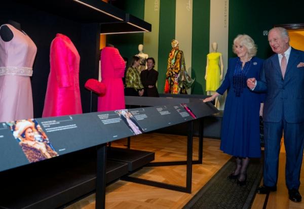 Le roi Charles III et la reine Camilla admirent des tenues portées par la défunte reine Elizabeth II, dans le cadre de la nouvelle exposition du Royal Collection Trust "La reine Elizabeth II : sa vie avec style", présentée à la King's Gallery du palais de Buckingham à Londres, le 20 avril 2026