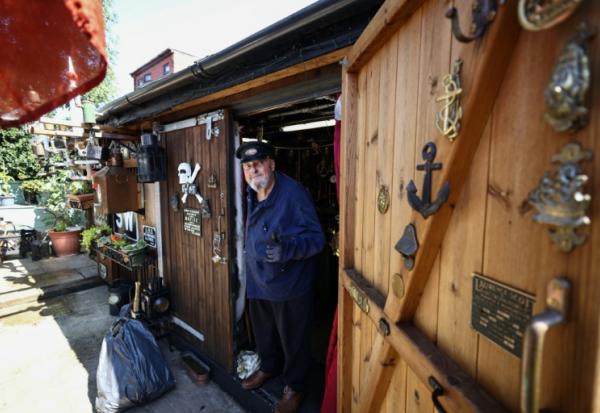 Peter McLaughlin à l'entrée de son abri de jardin, aménagé pour reproduire la chaufferie d'un navire, à l'arrière de sa maison à Londres, le 31 juillet 2026