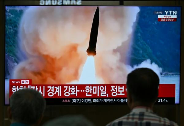 Un écran de télévision diffuse un journal télévisé avec des images d'archives d'un essai de missile nord-coréen, dans une gare de Séoul, le 20 août 2026 en Corée du Sud