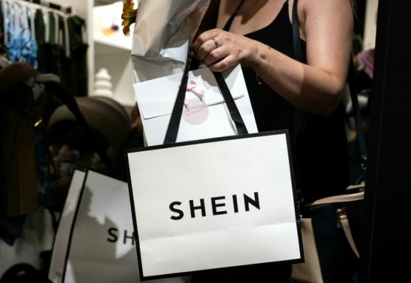 Une cliente à la sortie d'un magasin éphémère de la marque chinoise de fast fashion Shein à Dijon, le 26 juin 2025