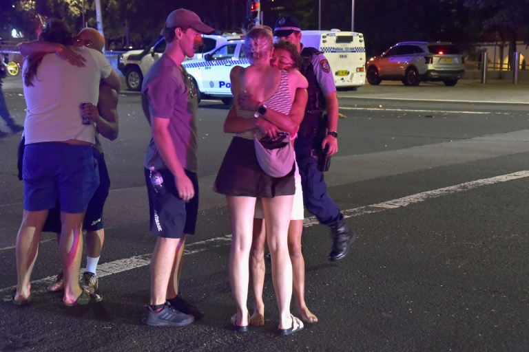 Des gens s'étreignent après l'attaque contre une fête juive sur la plage de Bondi, à Sydney, qui a fait onze morts et 29 blessés, le 14 décembre 2025
