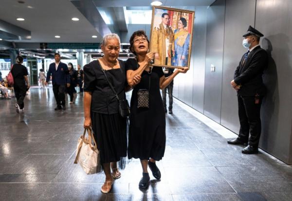 Des Thïlandaises tiennent des portraits de la reine mère Sirikit, le 25 octobre 2025 à l'hôpital Chulalongkorn de Bangkok où elle est décédée.