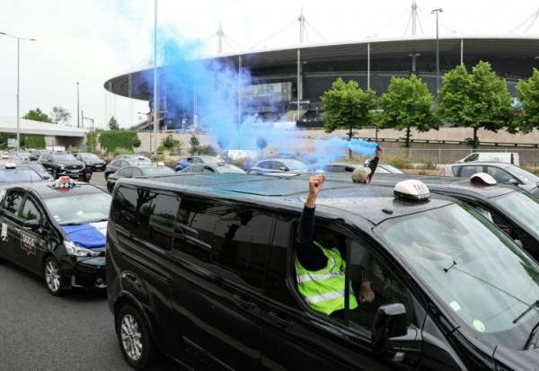 Des taxis allument des fumigènes lors d'une manifestation sur l'autoroute A1, le 21 mai 2025 à Saint-Denis