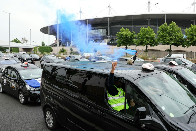 Des taxis allument des fumigènes lors d'une manifestation sur l'autoroute A1, le 21 mai 2025 à Saint-Denis