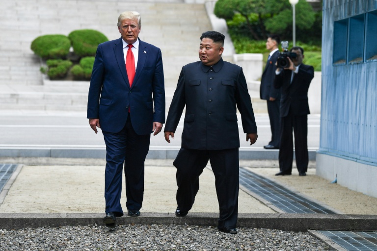 Le président américain Donald Trump (g. et le dirigeant nord-coréen Kim Jong Un traversent ensemble la ligne de démarcation militaire qui sépare la Corée du Nord et la Corée du Sud, le 30 juin 2019 à Panmunjom en Corée du Sud