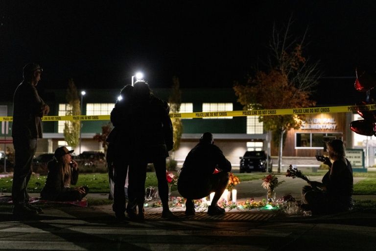 Des personnes devant un mémorial improvisé aux abords de l’école primaire Silver Rail, après une fusillade à Bend, le 15 octobre 2026 dans l'Oregon