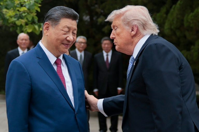 Le président américain Donald Trump (d) et le président chinois Xi Jinping à la sortie du jardin Zhongnanhai, avant de quitter Pékin, le 15 mai 2026