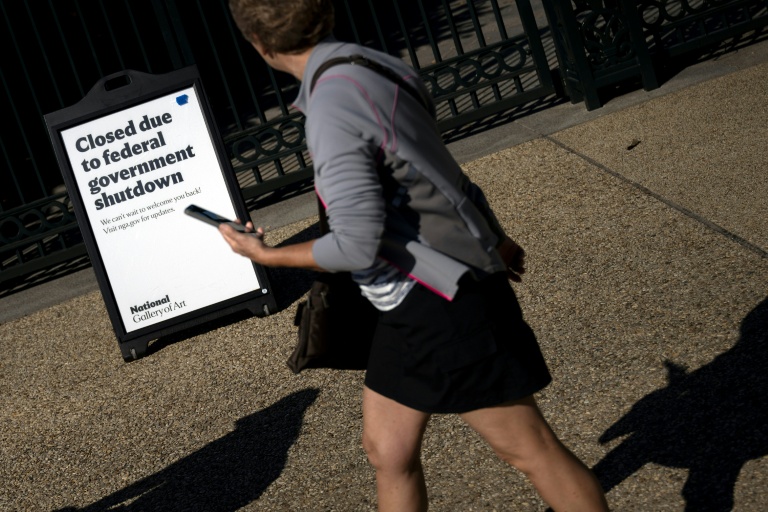 Une femme passe devant une pancarte de la National Gallery of Art à Washington, annonçant que le musée est fermé en raison du blocage budgétaire en cours au Congrès, le 6 octobre 2025