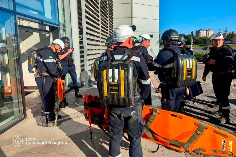 Photo diffusée par le Service d'État ukrainien pour les situations d'urgence, le 21 août 2026, montrant des pompiers luttant contre un incendie sur le site d'un centre commercial endommagé par une frappe russe à Kryvyï Rih, en Ukraine