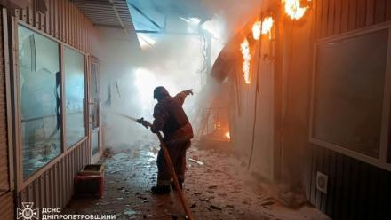 Photo prise et distribuée le 4 avril 2026 par le ministère des situations d'urgence ukrainien montrant des pompiers en train d'éteindre un incendie sur un marché après une frappe à Nikopol, dans le centre-est du pays