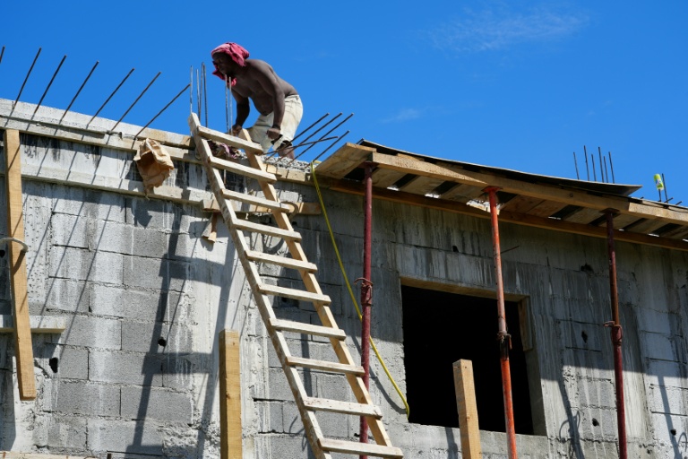 Un ouvrier reconstruit le toit d'une maison à Mamoudzou, un an après le passage du cyclone Chido à Mayotte, le 4 décembre 2025