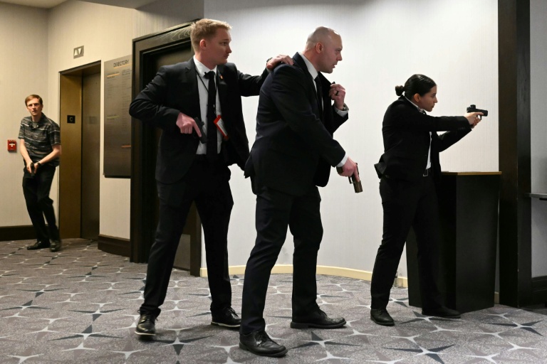 Des agents sont armes au poing après que des détonations ont été entendues au dîner des correspondants de la Maison Blanche, à l'hôtel Washington Hilton, le 25 avril 2026 à Washington
