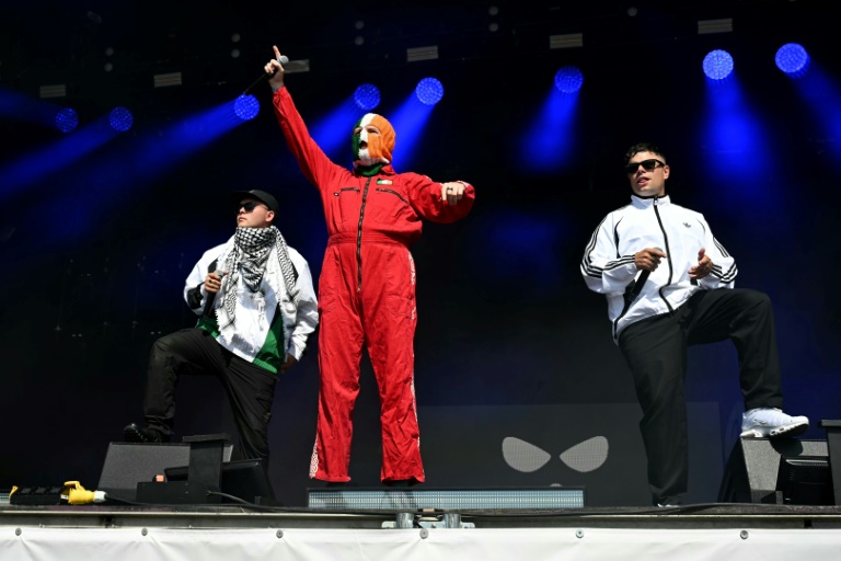 Mo Chara (g), DJ Provai (c) et Moglai Bap du groupe de rap irlandais Kneecap sur la scène de West Holts, au quatrième jour du festival de Glastonbury à Pilton, dans le sud-ouest de l'Angleterre, le 28 juin 2025