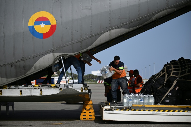 Déchargement de packs de bouteilles d'eau d'un avion de l'armée de l'air colombienne à l'aéroport international Simón Bolívar de La Guaira, le 26 juin 2026 au Venezuela après deux séismes dévastateurs 