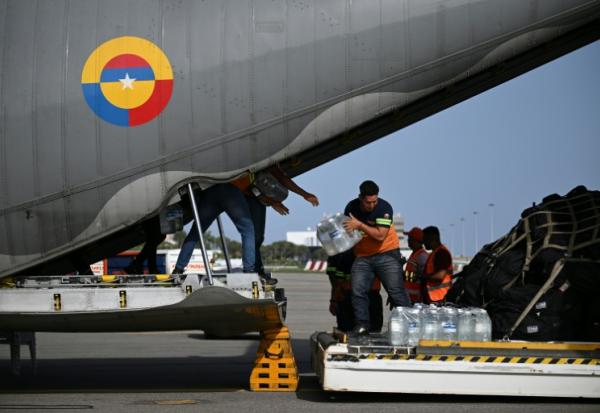 Déchargement de packs de bouteilles d'eau d'un avion de l'armée de l'air colombienne à l'aéroport international Simón Bolívar de La Guaira, le 26 juin 2026 au Venezuela après deux séismes dévastateurs 