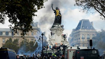De la fumée enveloppe la Statue de la République, recouverte d'une banderole jaune, lors d'une manifestation contre la vie chère, place de la République à Paris, le 17 octobre 2026