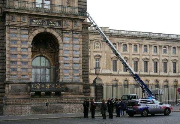 Des policiers français se tiennent à côté du monte-charge utilisé par des cambrioleurs pour pénétrer dans le musée du Louvre, sur le quai François Mitterrand, à Paris, le 19 octobre 2025