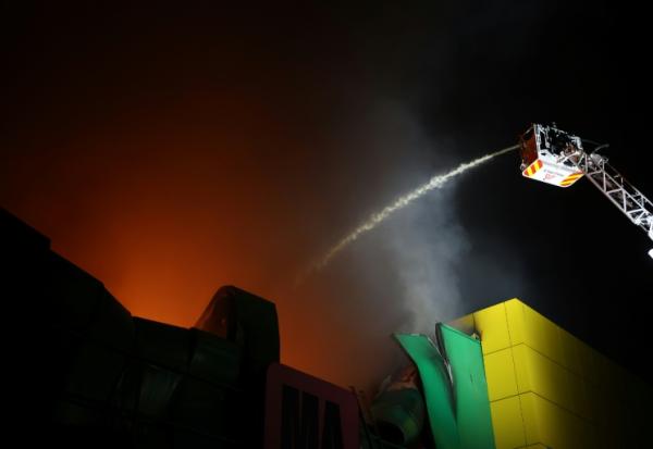 Des pompiers sur le site d’un centre commercial endommagé par une frappe de missile russe à Kiev, le 22 octobre 2026 en Ukraine