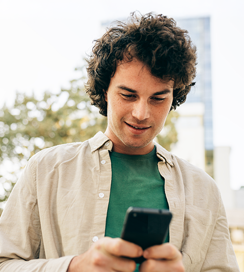 Une cliente souriante profite de son offre depuis son mobile